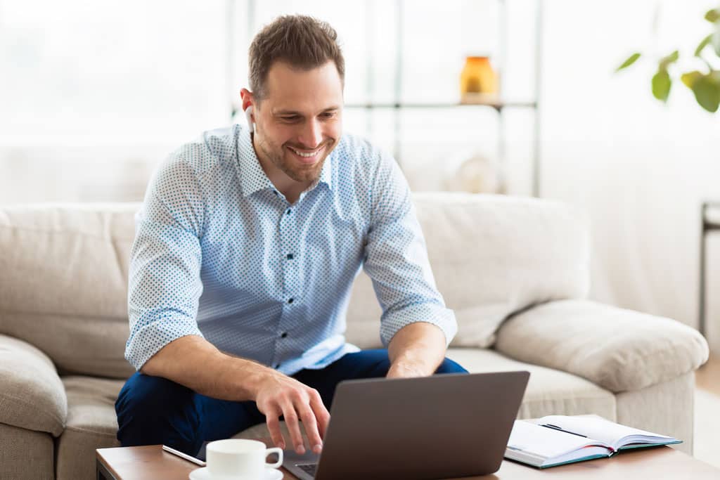 Article carrousel linkedin - Un homme souriant interagissant avec son ordinateur