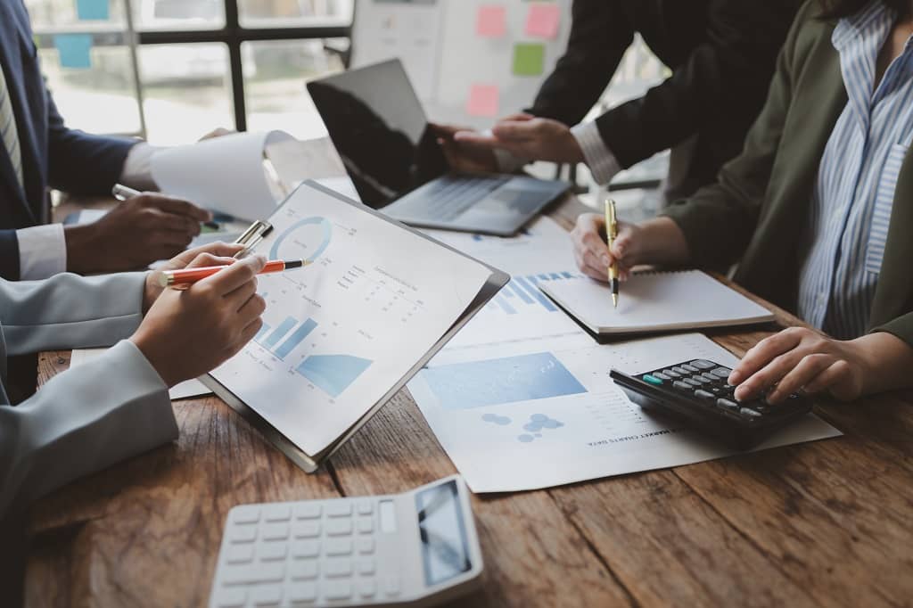 Article gestionnaire de publicité - Un groupe de collègues travaillant autour d'un bureau sur des graphiques et analyses