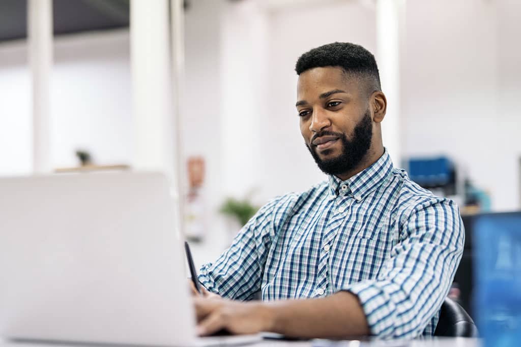 Article packshot 3D - Un expert 3D travaillant sur son ordinateur avec sourire