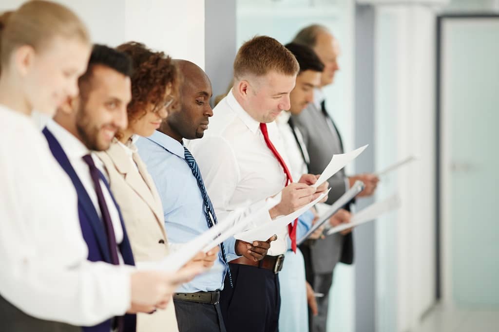 Article social ads expert - Un groupe de personnes debout côte à côte en train de lire une feuille