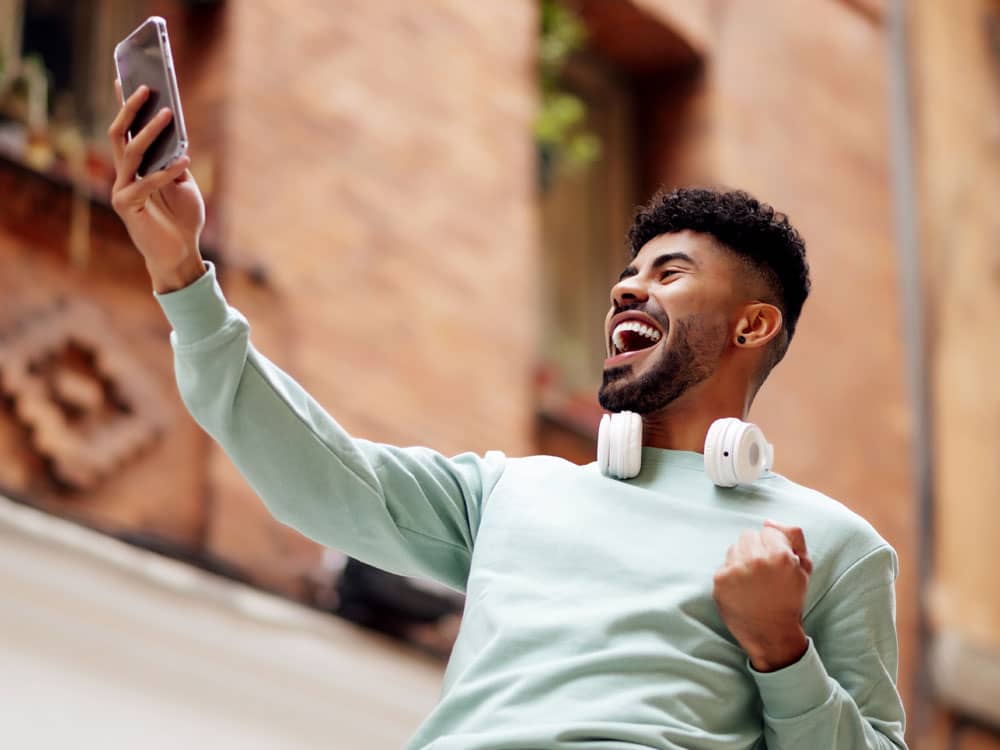 Article stratégie tiktok - un homme heureux devant son téléphone